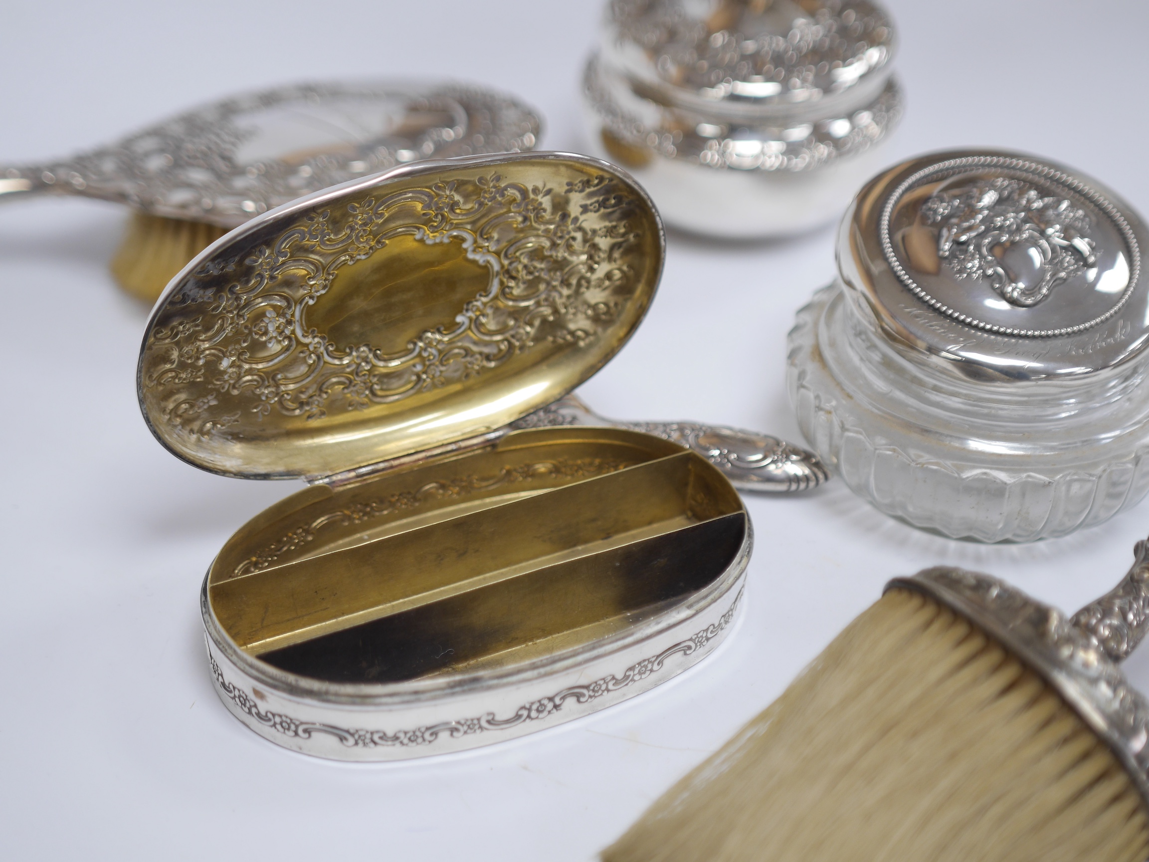 A late 19th/early 20th century Tiffany & Co sterling silver and silver mounted toilet set, comprising a hand mirror, two brushes, a shoe horn, powder jar and compartmental box with engraved inscription, 14cm, all engrave